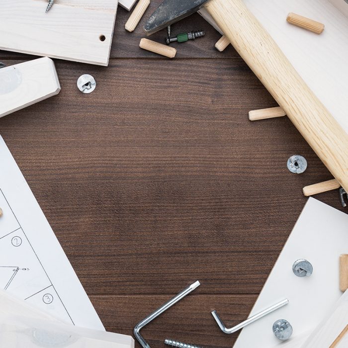 furniture piece parts and tools on the wooden table with copy space during assembly process