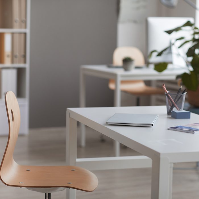 Image of empty desk with laptop at modern empty office